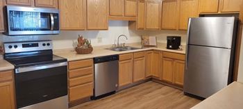 A kitchen with wooden cabinets and stainless steel appliances.